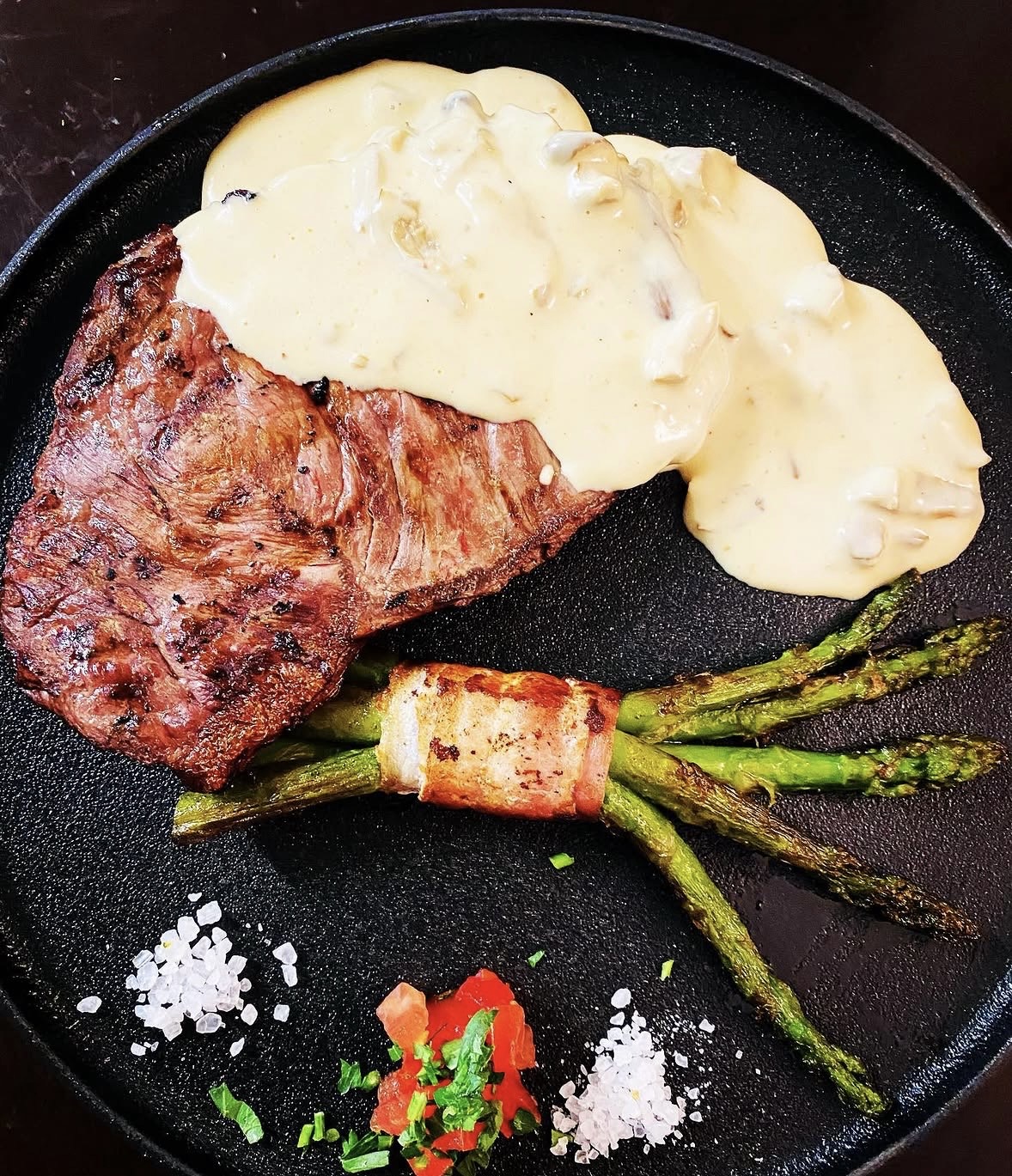 Gegrilltes Steak mit Champignonsoße und grünem Spargel